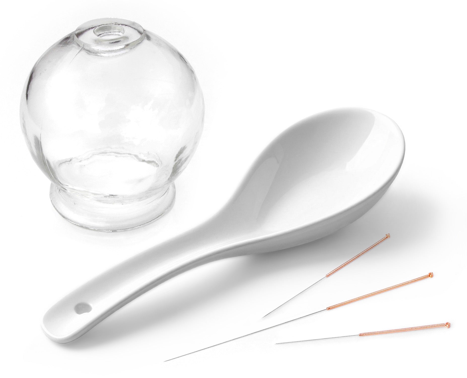 Acupuncture materials: A glass cup for cupping, a Gua Sha spoon, and acupuncture needles.