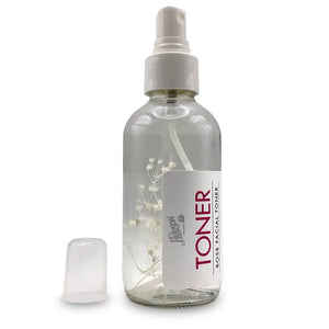 Clear spray bottle with white flower/plant inside and white label.