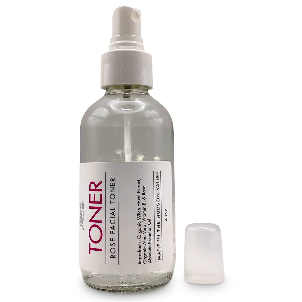 Clear spray bottle with white flower/plant inside and white label.