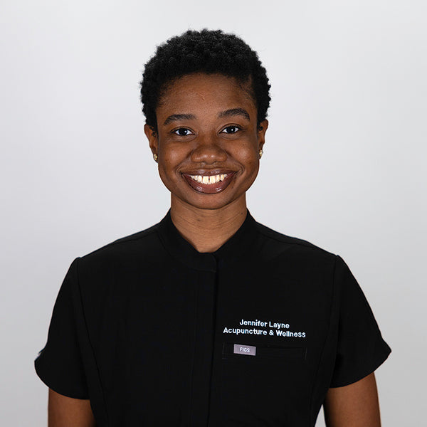 Headshot of Adekunbi Lahanmi, smiling, wearing black scrubs.