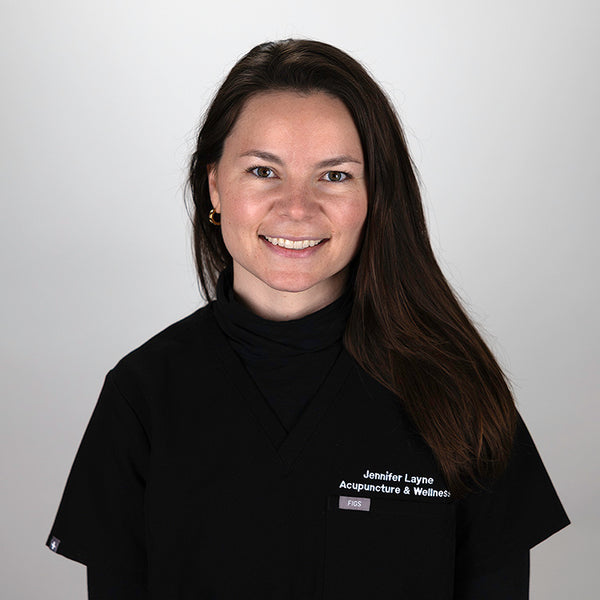 Headshot of Alexa Wilson, smiling, wearing black scrubs.