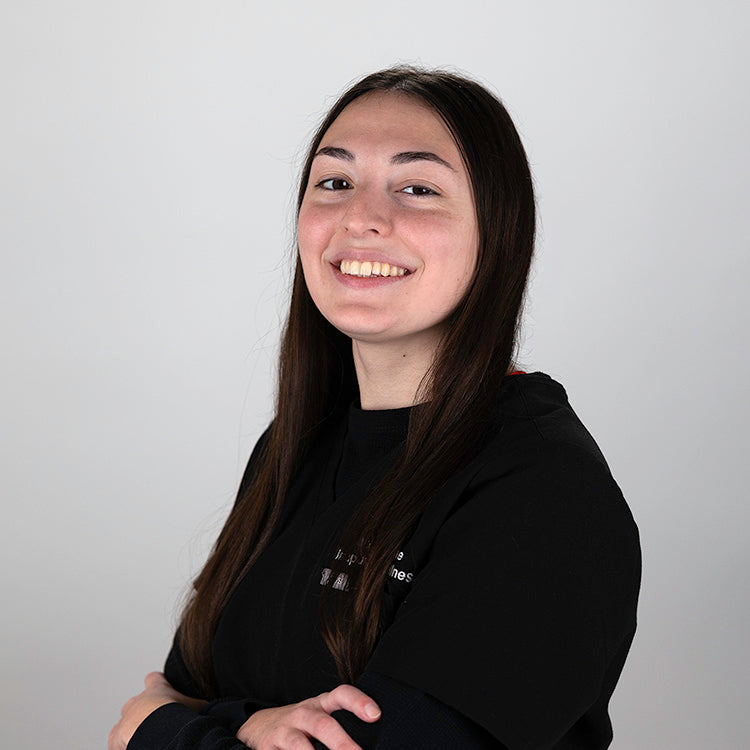 Headshot of Angelica Krajnik, smiling, wearing black scrubs.