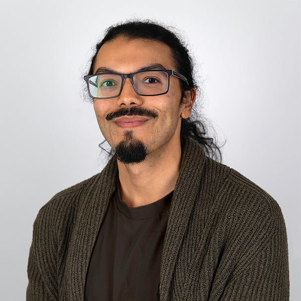 Headshot of Henry Espinal, smiling, wearing a dark shirt and sweater.