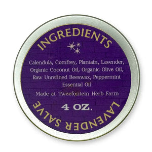 Back of round metal container of 4 oz  lavender salve which includes ingredients on a purple background.